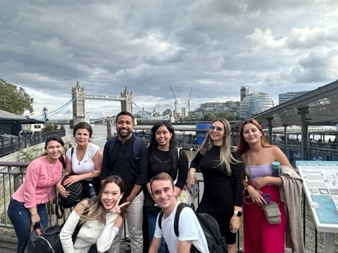 Happy students in a social, posing in front of Tower Bridge