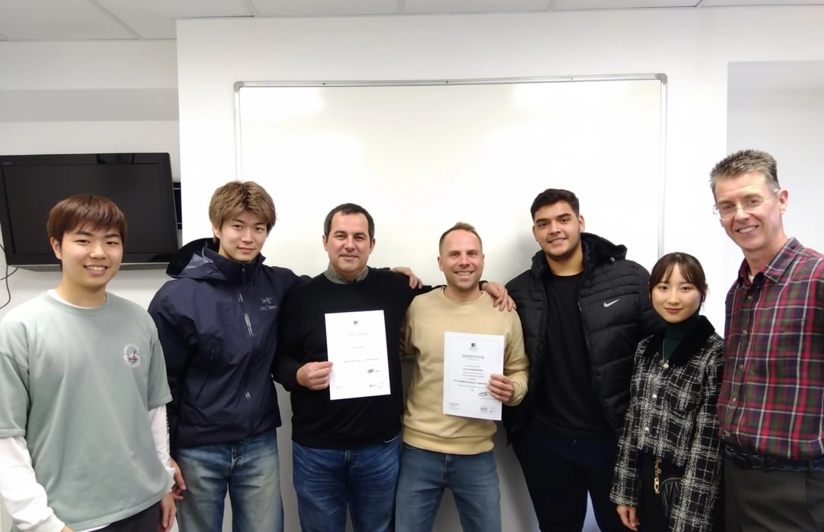 Students and a teacher smiling and posing for a graduation photo.